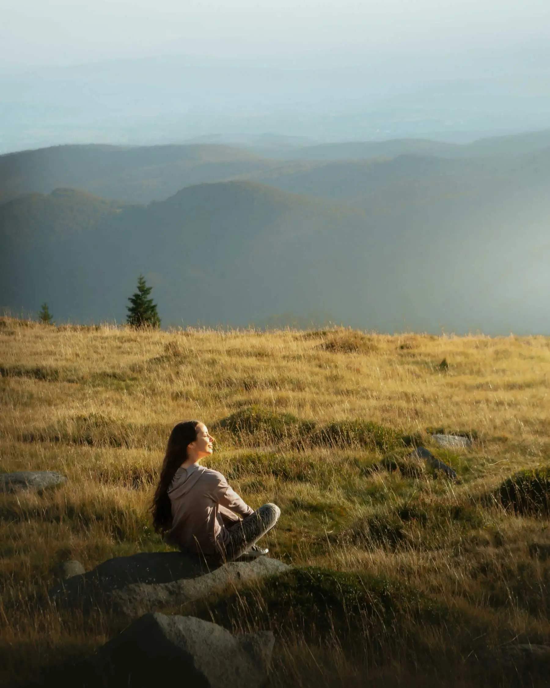 femme_detente_pre Une femme détendue, assise seule dans un pré en pleine nature, face au soleil.